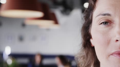 Half-portrait-of-happy-caucasian-casual-businesswoman-in-office-with-copy-space,-slow-motion