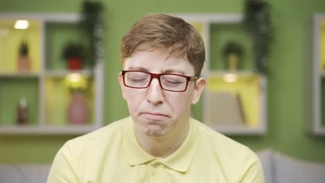 close-up of unhappy and depressed young man looking at camera.