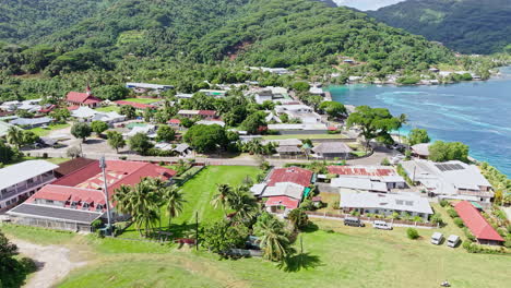 drone shot of fare, huahine island, french polynesia. village buildings, port and scenic landscape
