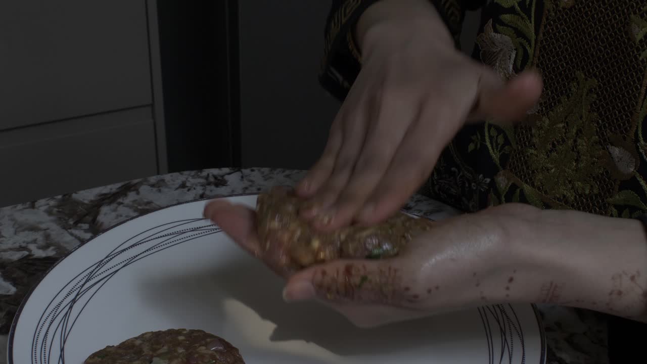 mujer musulmana haciendo kebabs con carne picada