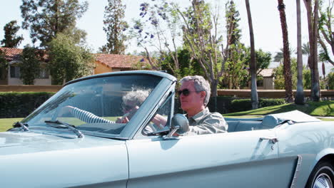 Senior-white-couple-on-the-road-in-a-classic-convertible-car