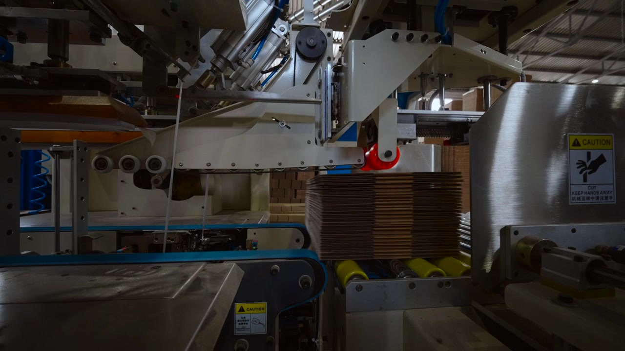 Conveyor system moves past brushed steel rollers and metal guides as pneumatic cylinders operate, with industrial, machinery, factory, automation detail, showing packaging, conveyor, roller, belt
