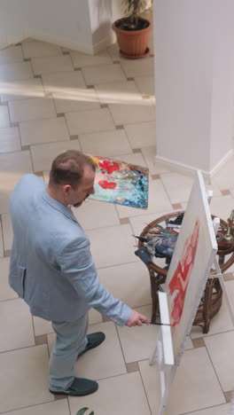 el maestro de arte inspirado dibuja a una mujer en el estudio. una dama bonita en vestido posa para el pintor en el dibujo de modelo de vida en la galería. artista trabajando en una obra maestra