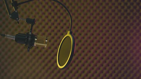 vista estática de un micrófono dorado en un estudio de grabación profesional lleno de humo