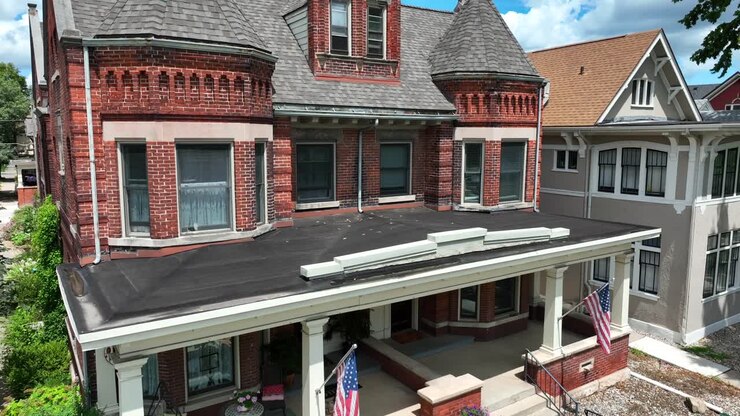 Amerikanske flag på stort victoriansk hus i en amerikansk forstad