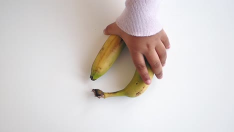 hand holding two bananas