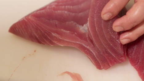 Sharp-Knife-Used-In-Slicing-Raw-Meat-Of-Fresh-Tuna-Fish-For-Preparing-Sushi-In-A-Japanese-Restaurant---close-up,-slow-motion