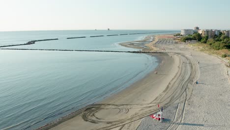 Toma-Aérea-De-Playa-De-Arena-Con-Sombrillas-Y-Mar-Adriático,-Costa-Típica-De-Emilia-Romagna