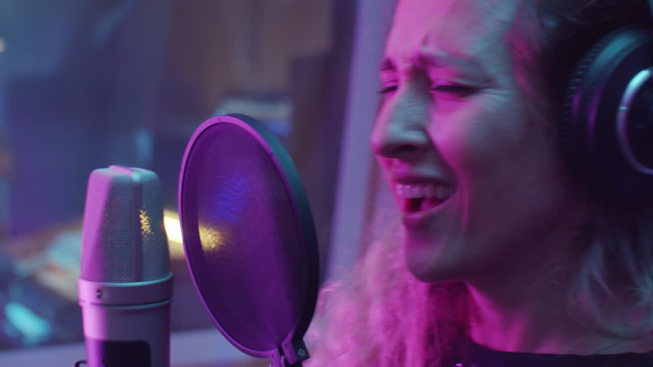 녹음 스튜디오에서 마이크로 노래하는 여성 보컬리스트