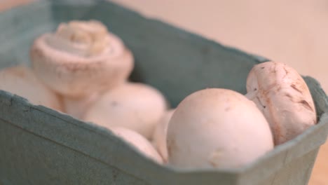 fresh white mushrooms in a cardboard box