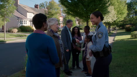 group of people talking to police officer in neighborhood