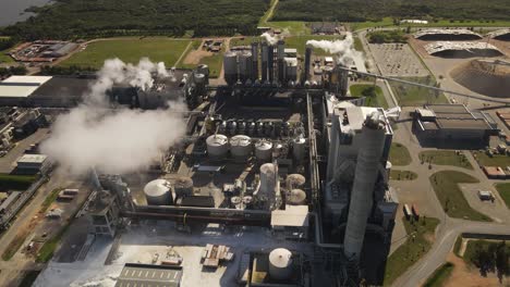 smoke pollution from paper mill factory, rotating aerial view