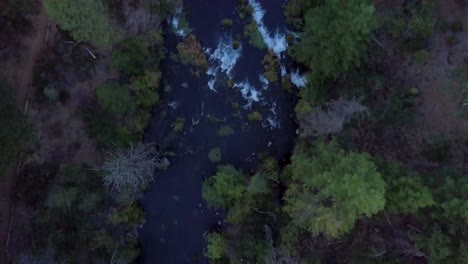 Drohne-Folgt-Dem-Fluss-Von-Oben-Nach-Unten,-Um-Den-Wasserfall-Burney-Falls-Freizulegen,-Und-Schwenkt-Dann-Bei-Sonnenuntergang-Zum-Wald-Im-Lassen-County-In-Nordkalifornien