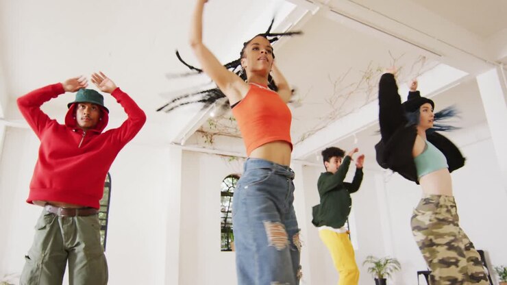 Happy diverse male and female dancers dancing in dance studio, slow motion
