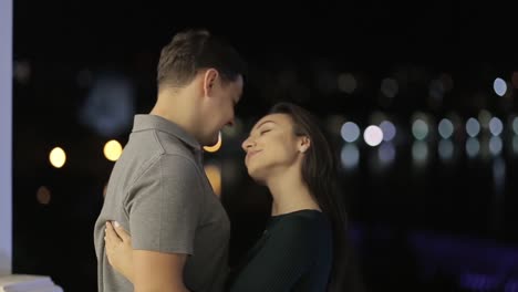 romantic couple embracing at night with city lights