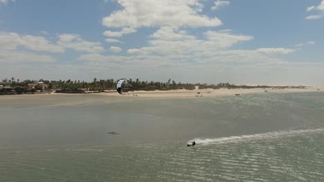 un kitesurfista montando en una laguna durante la marea baja