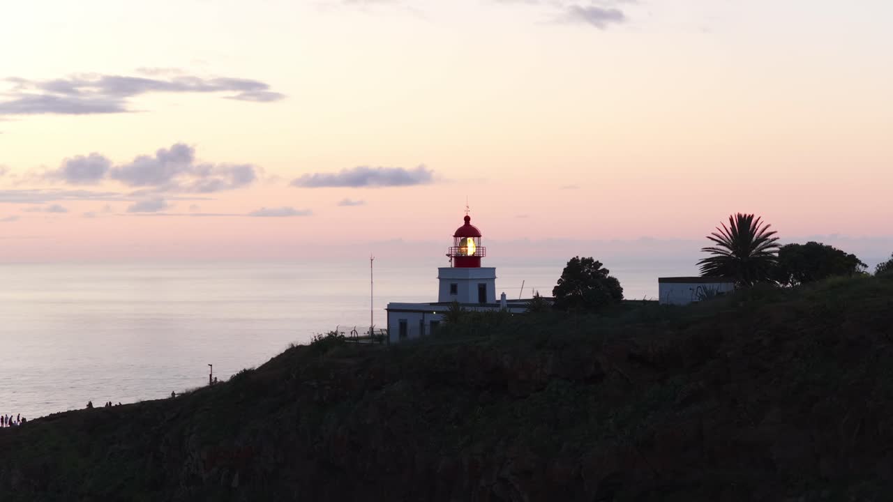 Farol da Ponta do Pargo lighthouse illuminating the Atlantic Ocean at sunset, Madeira, Portugal