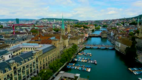 4k drone video of the historic fraumünster and st. peter churches on the banks of the limmat river in downtown zurich, switzerland (high speed)