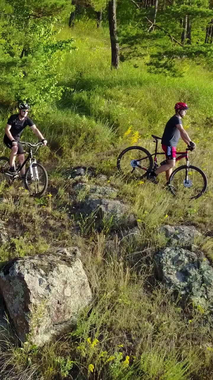 Men Riding Bicycle In Nature. Young male men in sportswear riding bicycle near forest
