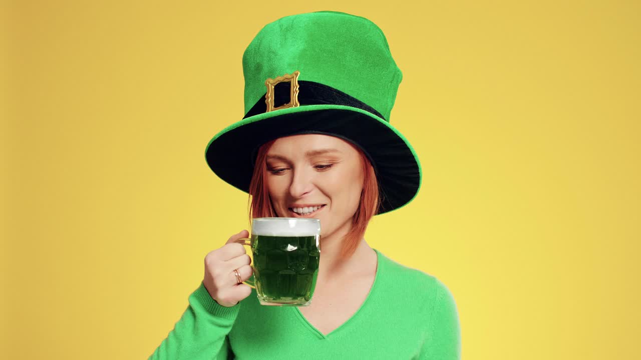 Woman with leprechaun's hat drinking beer in the studio shot