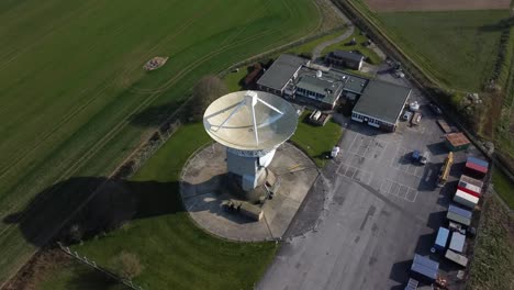 drone shot orbiting a large satellite dish and observatory in england