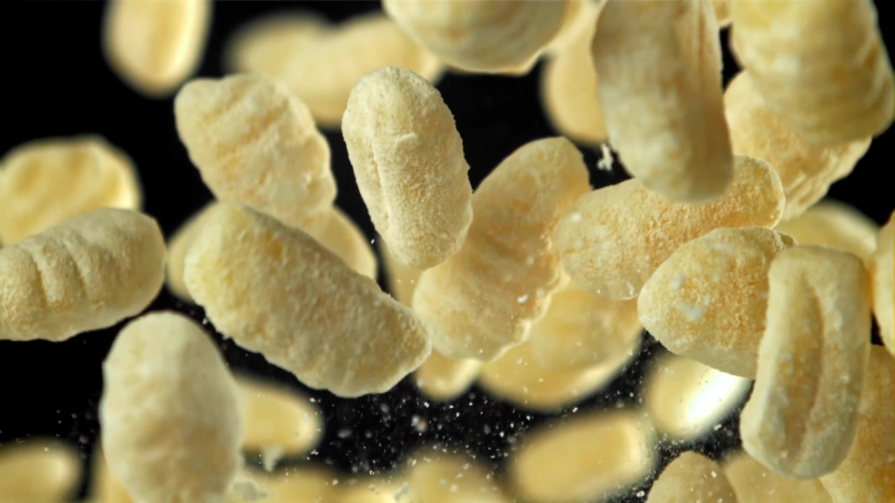 Soffietti di mais che cadono al rallentatore su sfondo nero