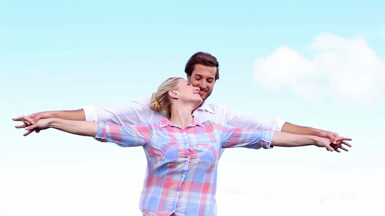 팔 을 펴고 서 있는 젊은 부부