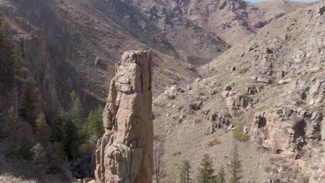 Orbiting-aerial-view-of-a-rock-climber-ascending-a-skinny-rock-in-Colorado's-Rocky-Mountains