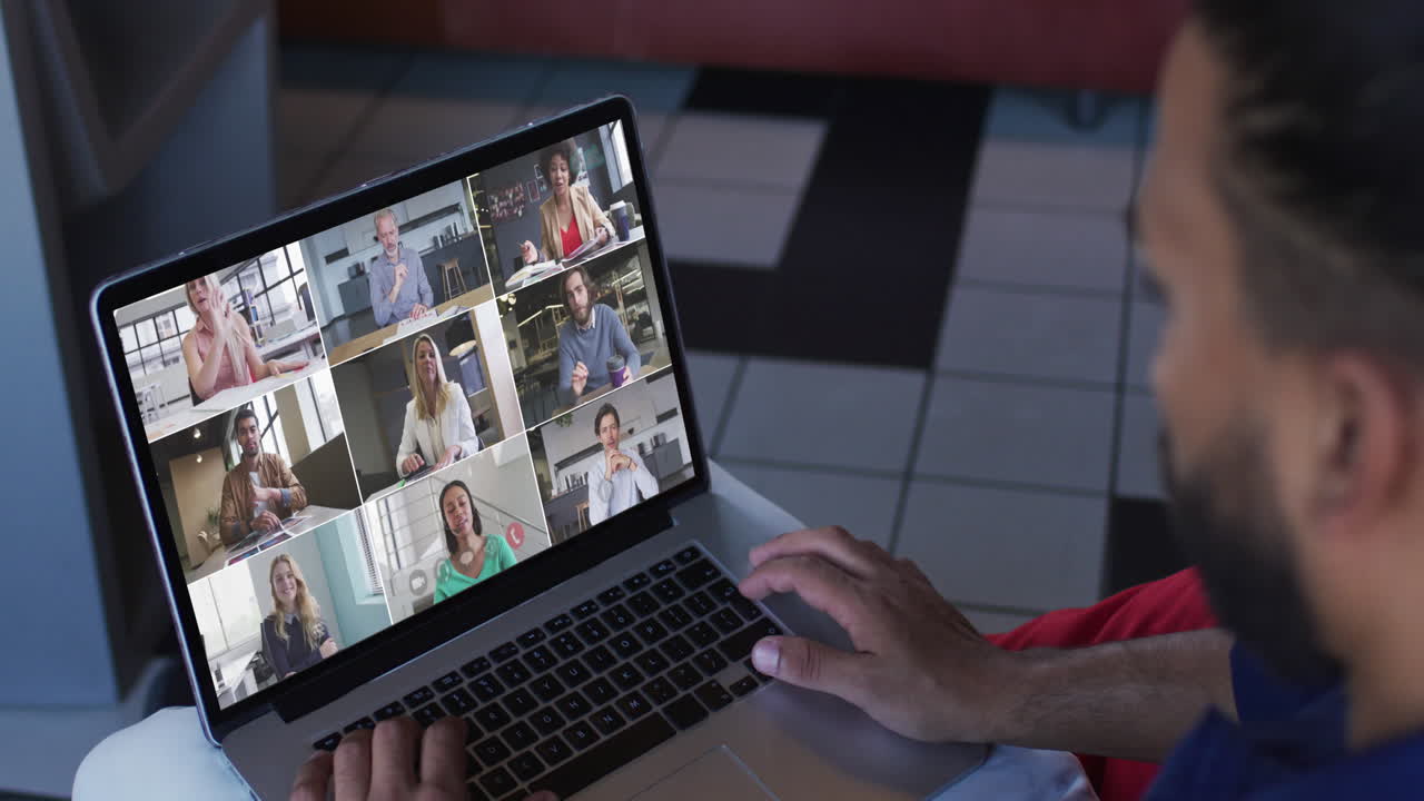 Uomo mediorientale in videoconferenza con colleghi d'ufficio sul laptop
