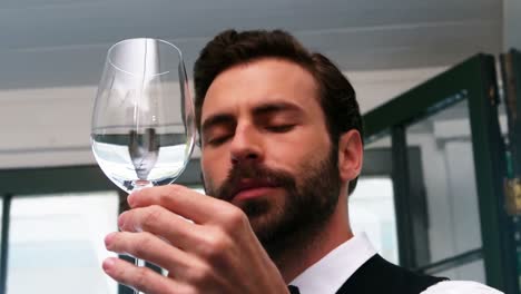 camarero examinando un vaso de vino vacío