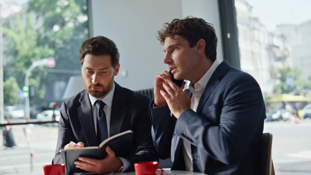 Office workers worried call working together tensely at panoramic cafe closeup