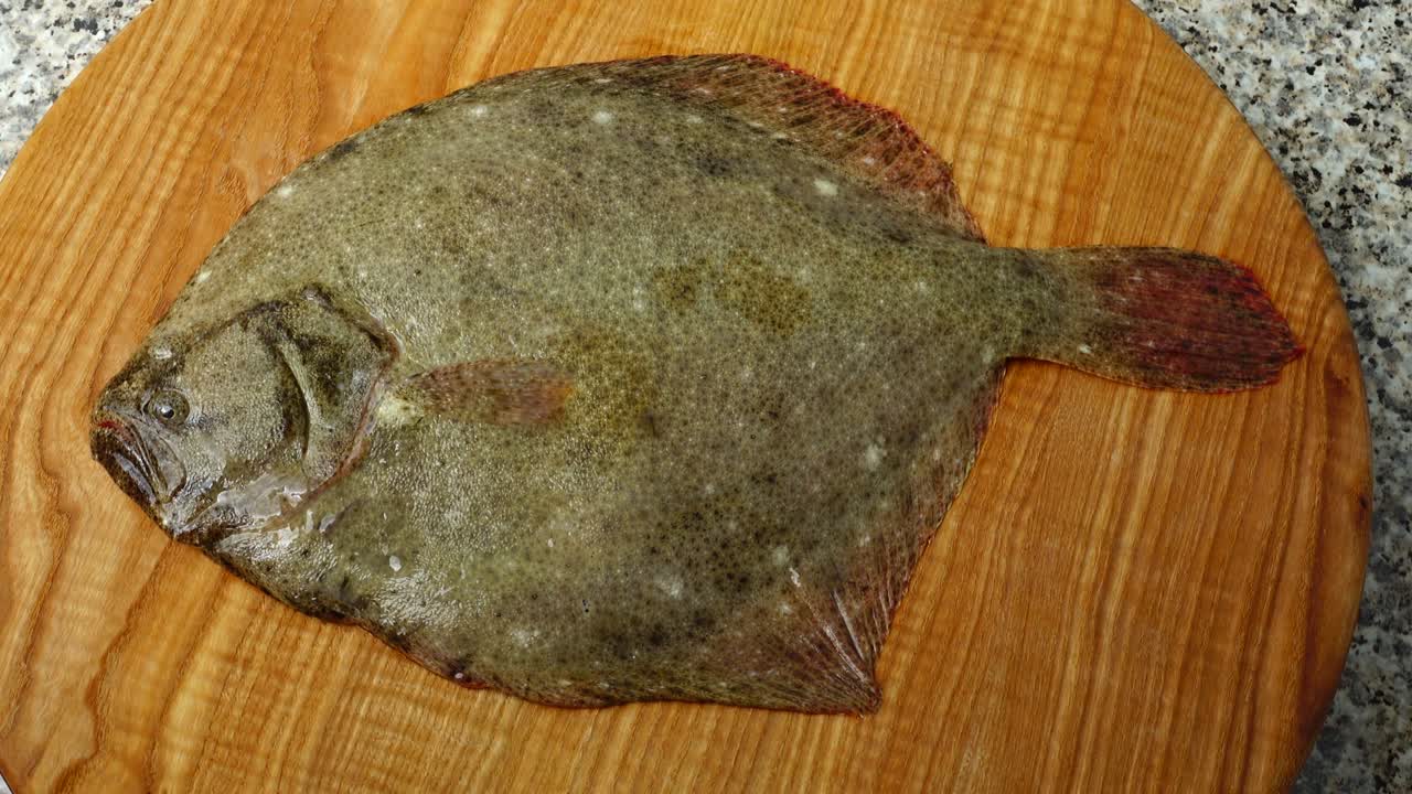 Pesce piatto su un tagliere. Riprese in movimento.