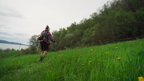 Mann-Schneidet-Grasbewachsenen-Hügel-Mit-Einer-Grasschneidemaschine