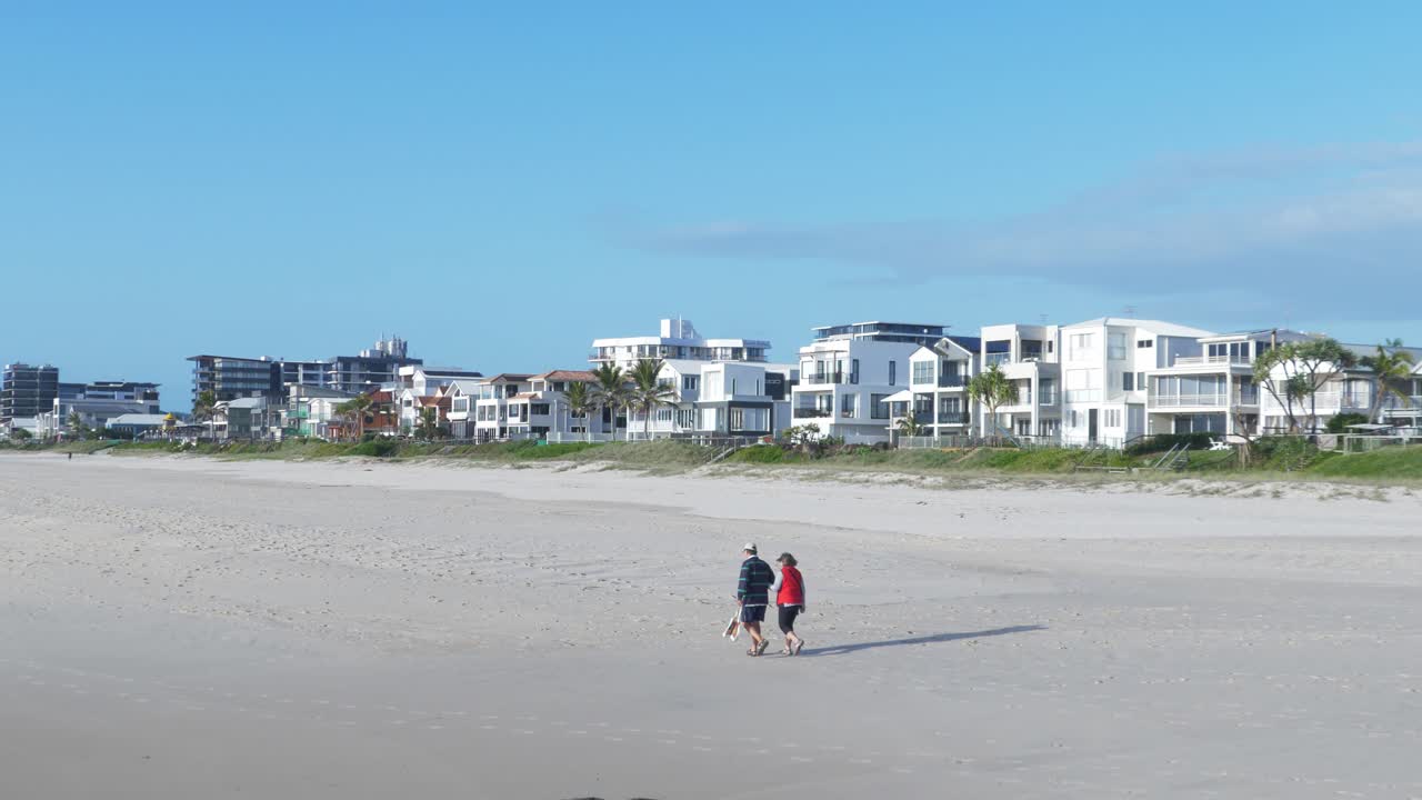 Encantadora pareja caminando por la orilla de la playa - Hoteles junto al mar en Palm Beach - Gold Coast, QLD, Australia