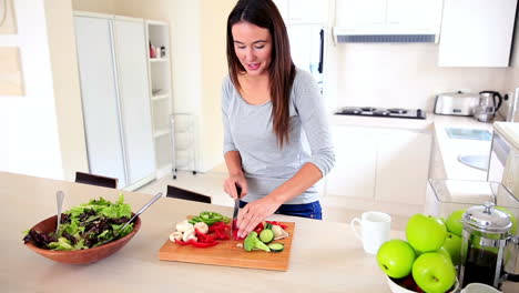 una bonita morena preparando una ensalada saludable