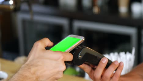Customer-making-payment-through-mobile-phone-at-counter-4k