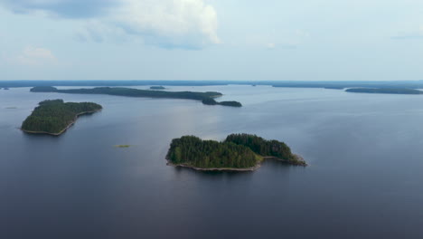 aerial ascending shot of an island on lake puruvesi, summer in saimaa, finland