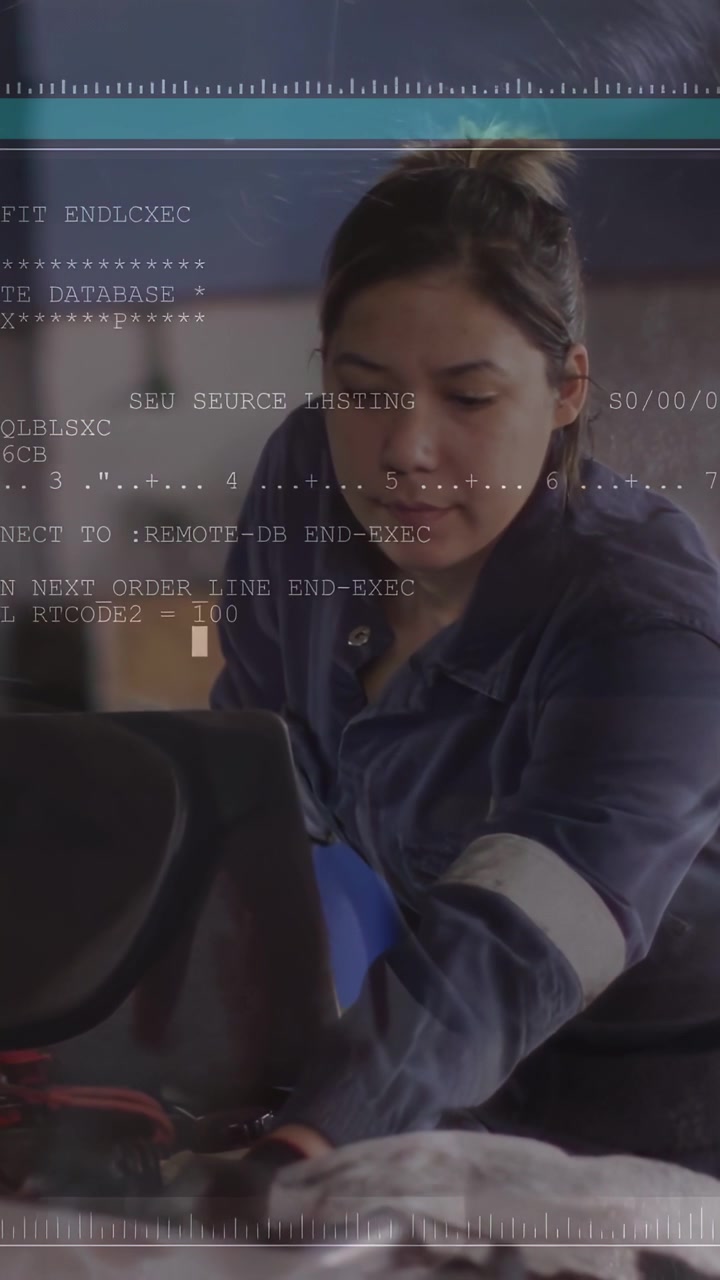 Video verticale: Tecnico al banco che usa un laptop e sistema i cavi, mostrando un terminale color verde acqua per un test automatico.