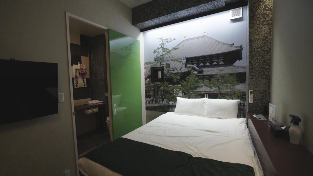 Moving towards bed in small hotel room