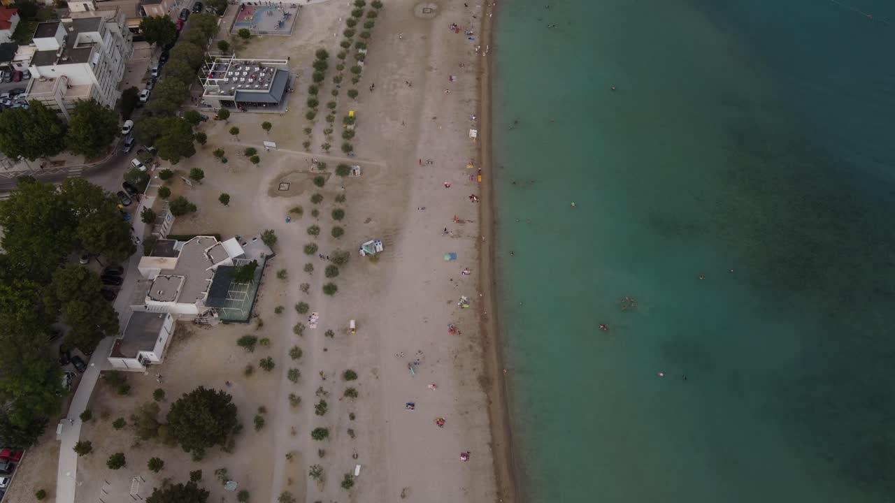 gente relajándose y nadando en la playa de velika plaza punta de la ciudad de omis en croacia