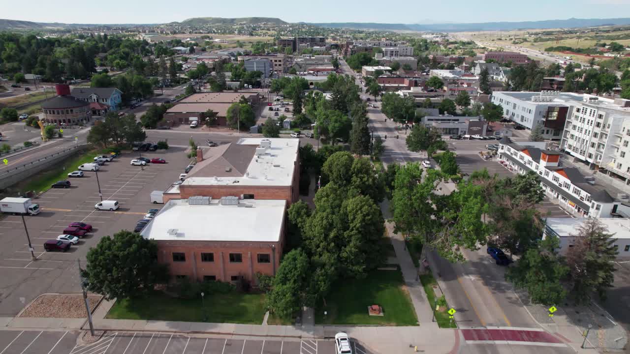 Aerial video of the town of Castle Rock in Colorado. Camera is flying low over buildings and near a road