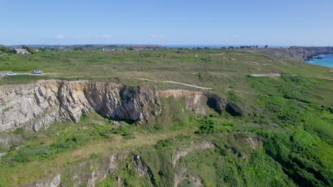 aerial hacia atrás sobre la costa de goulien beach y los acantilados en gran bretaña, francia