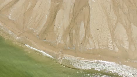 Direkte-Luftaufnahme-Von-Wellen,-Die-Gegen-Nassen-Sand-Plätschern