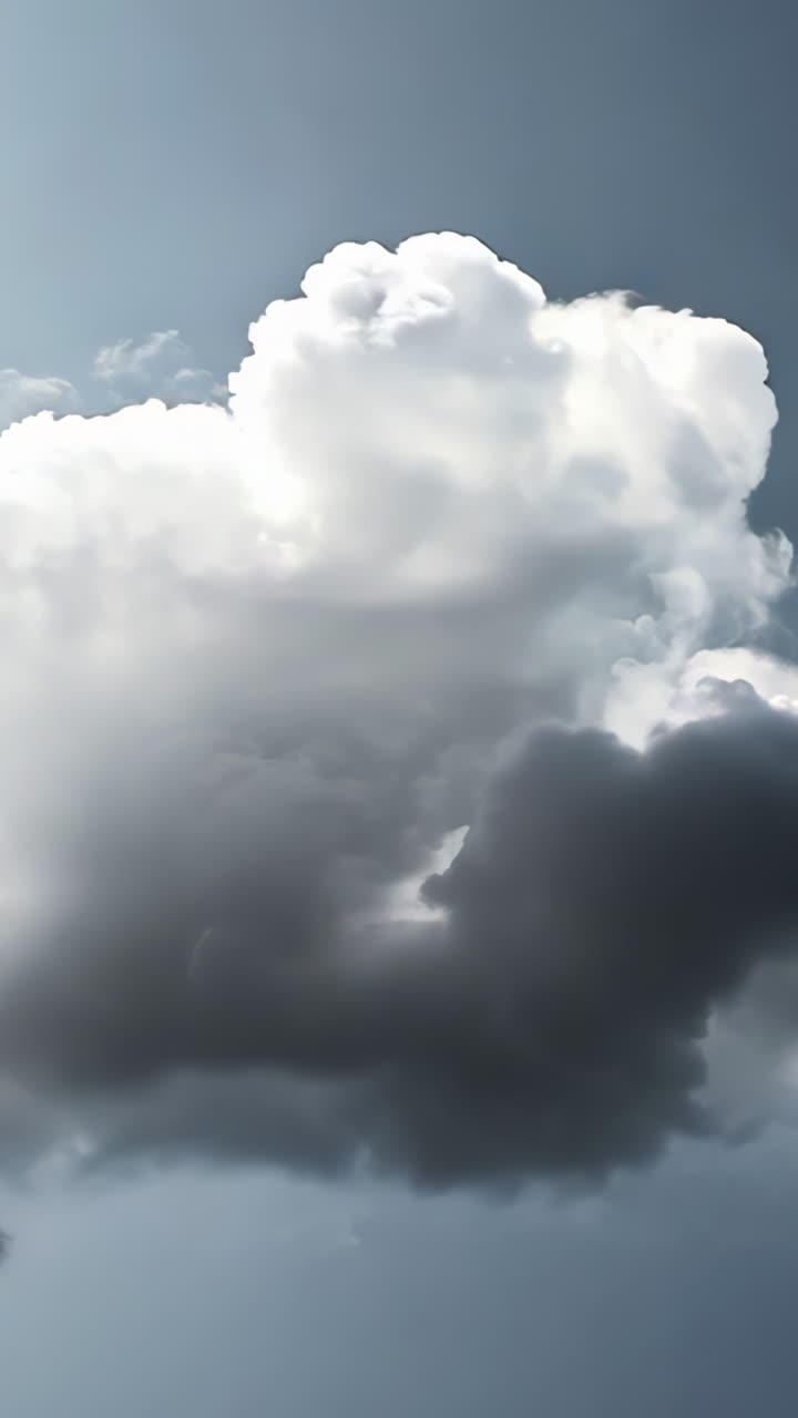 A large cloud of smoke is rising into the sky. The sky is a dark blue color. The smoke is thick and billowing, creating a sense of heaviness and unease