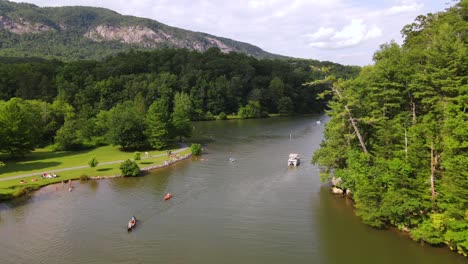 an excellent aerial shot of people kayaking and riding other boats on lake lure in chimney rock north carolina