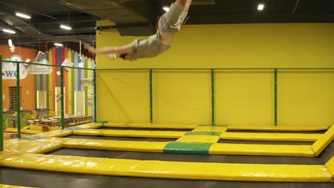 un joven deportista que está pasando el mejor momento de su vida disfrutando saltando en el trampolín, realizando saltos de mano.