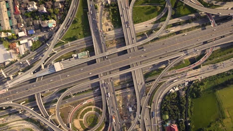 aerial view of highway road interchange with busy urban traffic speeding on road