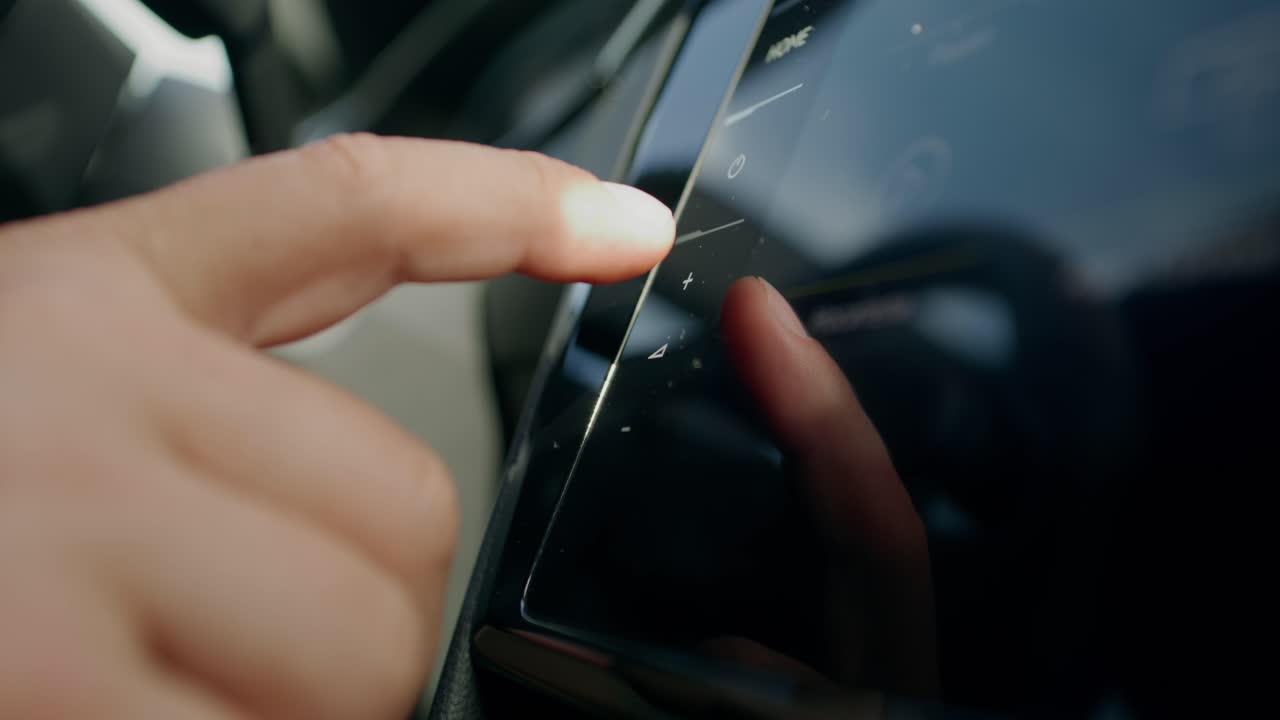 자동차 인포테인먼트 화면을 만지는 사람