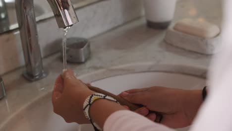 woman rinses a tooth brush
