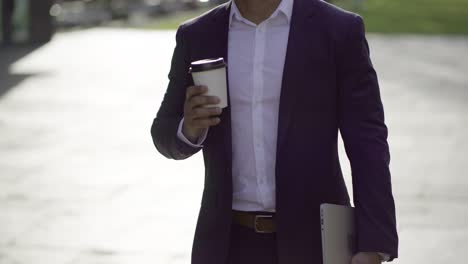 businessman with laptop and coffee to go on street